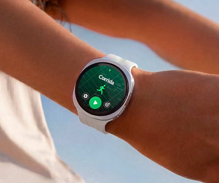 Uma pessoa está usando um Galaxy Watch9 na cor Prata com Pulseira Sport na cor Branco enquanto alonga os braços, e um programa de treino de corrida está aberto na tela do relógio, mostrando um mapa da rota de corrida com uma localização marcada.