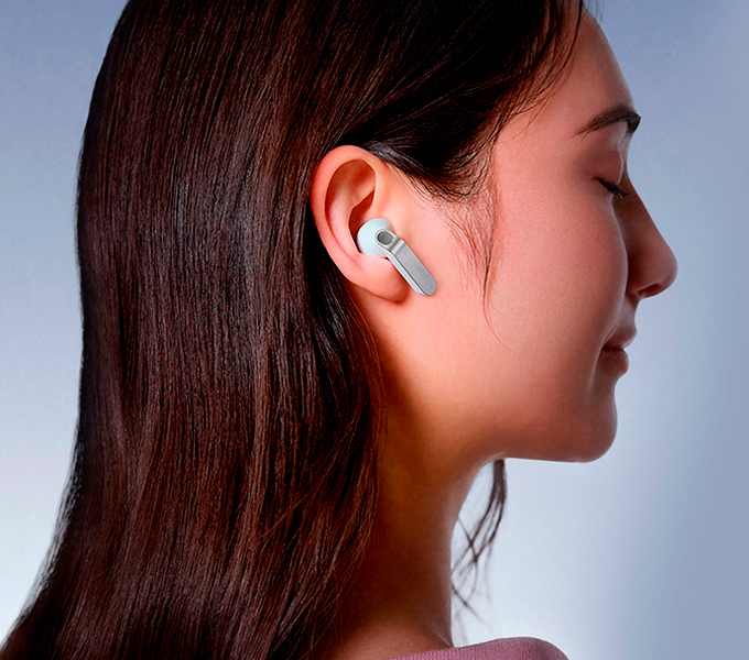 A imagem mostra os fones Galaxy Buds4 na cor branca em close, destacando as hastes de metal em diferentes ângulos.A cena alterna e vemos uma pessoa usando os Galaxy Buds4 na cor branca, de perfil, virada para a direita.
