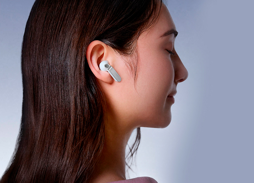 A imagem mostra os fones Galaxy Buds4 na cor branca em close, destacando as hastes de metal em diferentes ângulos. A cena alterna e vemos uma pessoa usando os Galaxy Buds4 na cor branca, de perfil, virada para a direita.