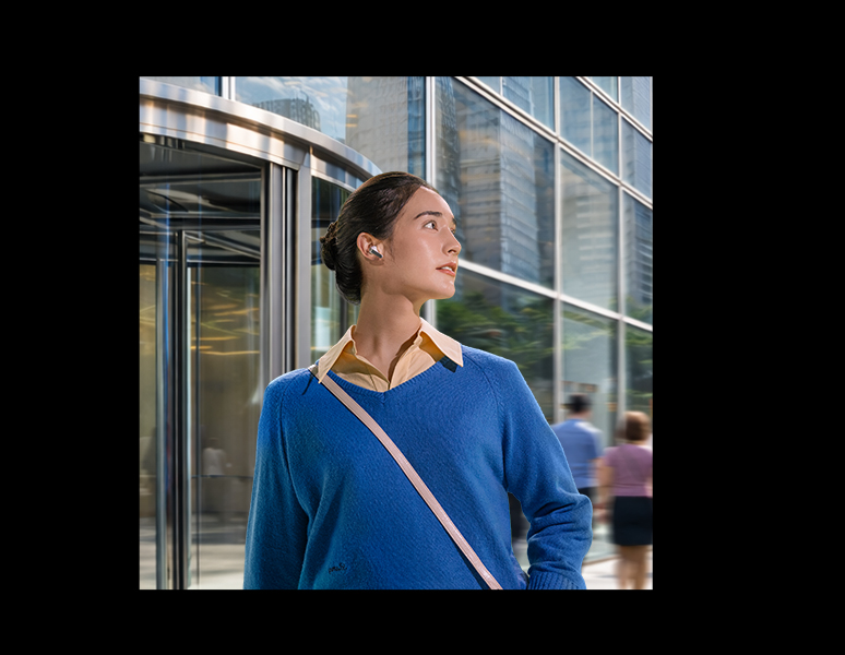 A imagem mostra uma mulher com um único fone Galaxy Buds4 Pro branco em sua orelha, olhando para a direita