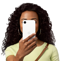 Uma pessoa segura um iPhone 16e em frente ao rosto