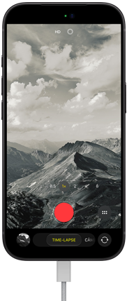 Parte da frente do iPhone 18 Pro mostrando uma paisagem montanhosa, com a sobreposição do modo da câmera no modo time-lapse, com o cabo de energia conectado à porta para recarga