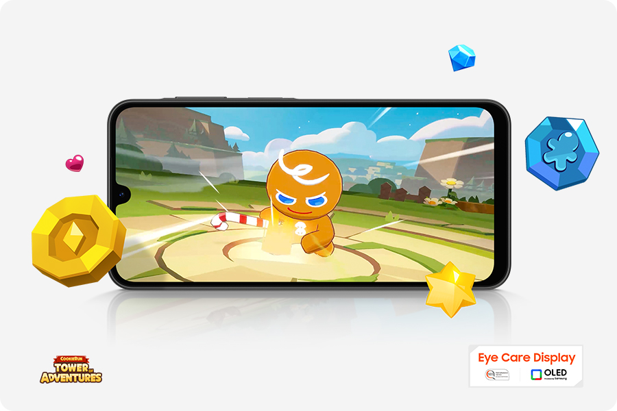 Vemos um Galaxy A26 5G rodando o jogo Cookie Run no modo paisagem. Itens do jogo estão espalhados ao redor da tela. Próximos ao dispositivo estão os logotipos de COOKIE RUN TOWER OF ADVENTURES, Eye Care Display e OLED Technology.