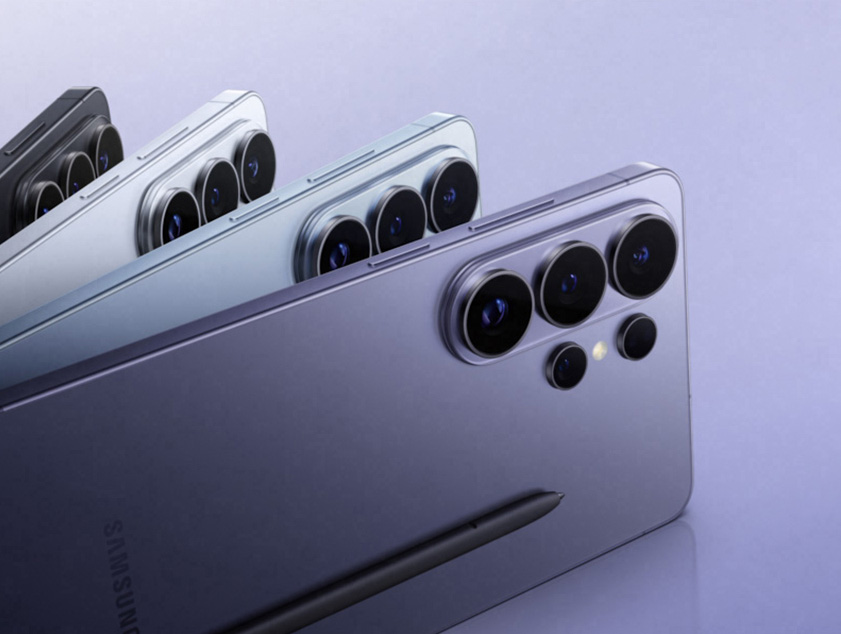 Vemos o Galaxy S26 Ultra em Violeta de lado. Ao girar, as câmeras traseiras entram em destaque. Em seguida, mais três aparelhos em Azul, Branco e Preto se abrem em leque a partir do primeiro, também vistos por trás. A S Pen desliza e aparece na cena.